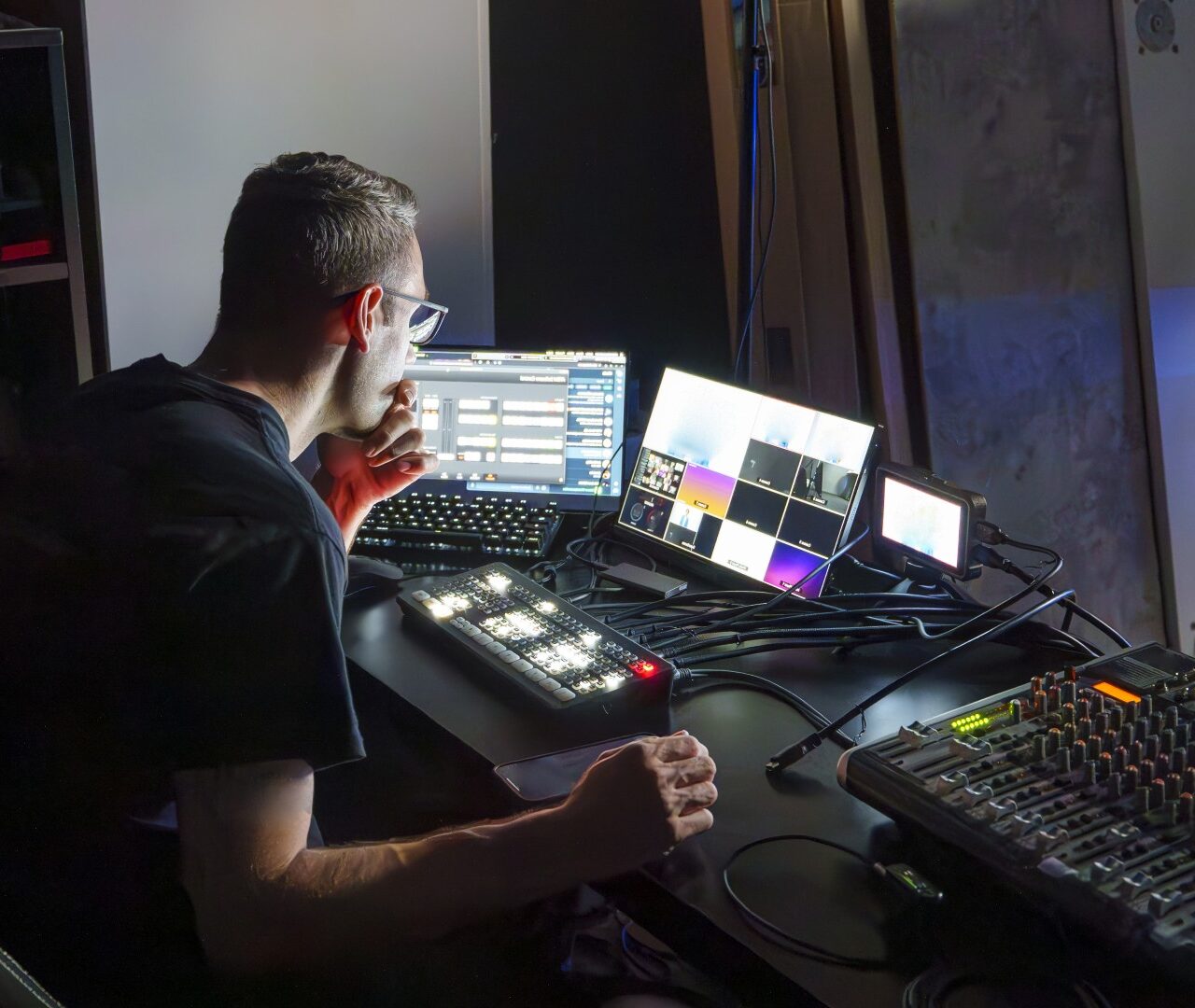 Man geconcentreerd achter regie-/monitorscreens