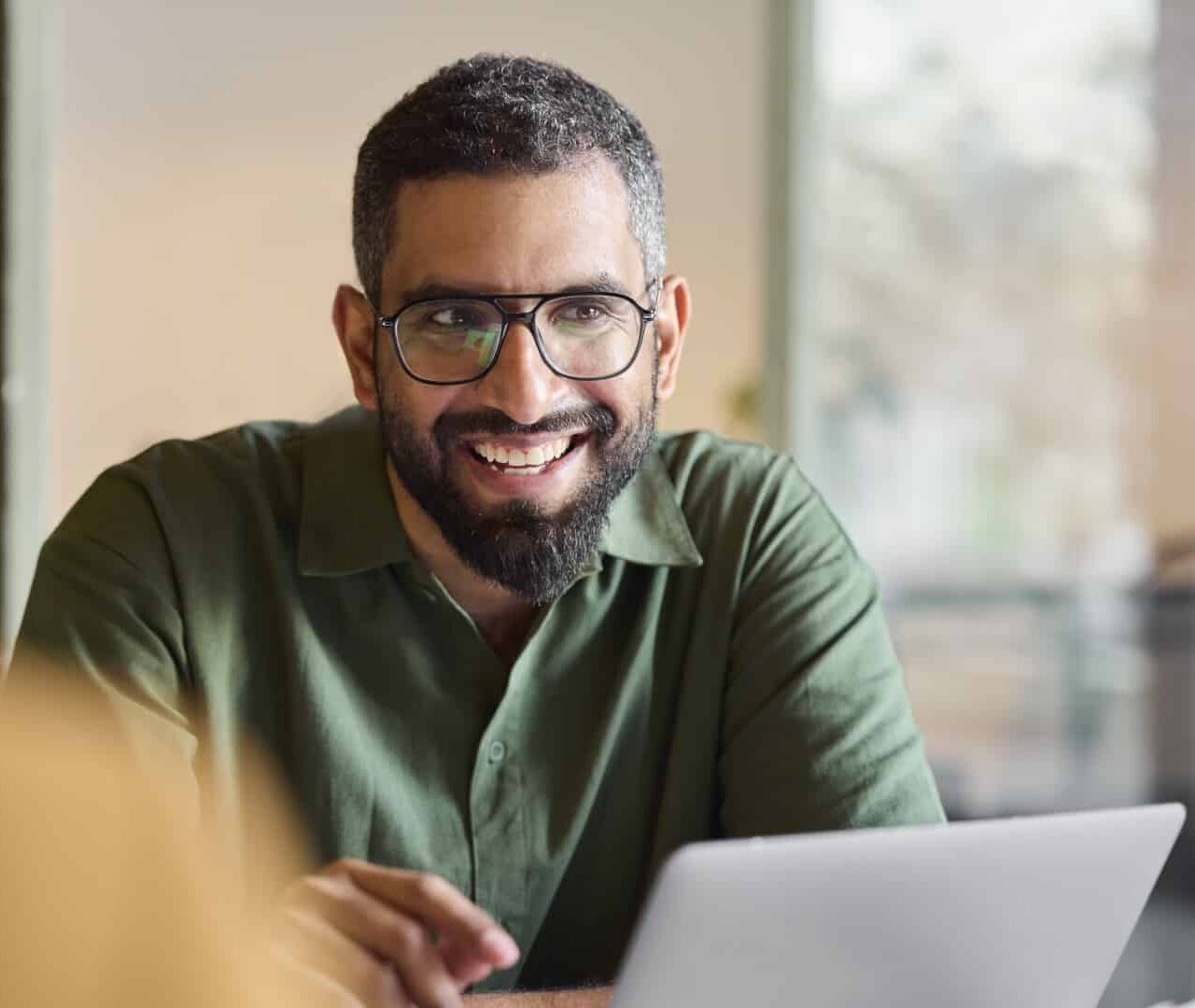 lachende man achter laptop