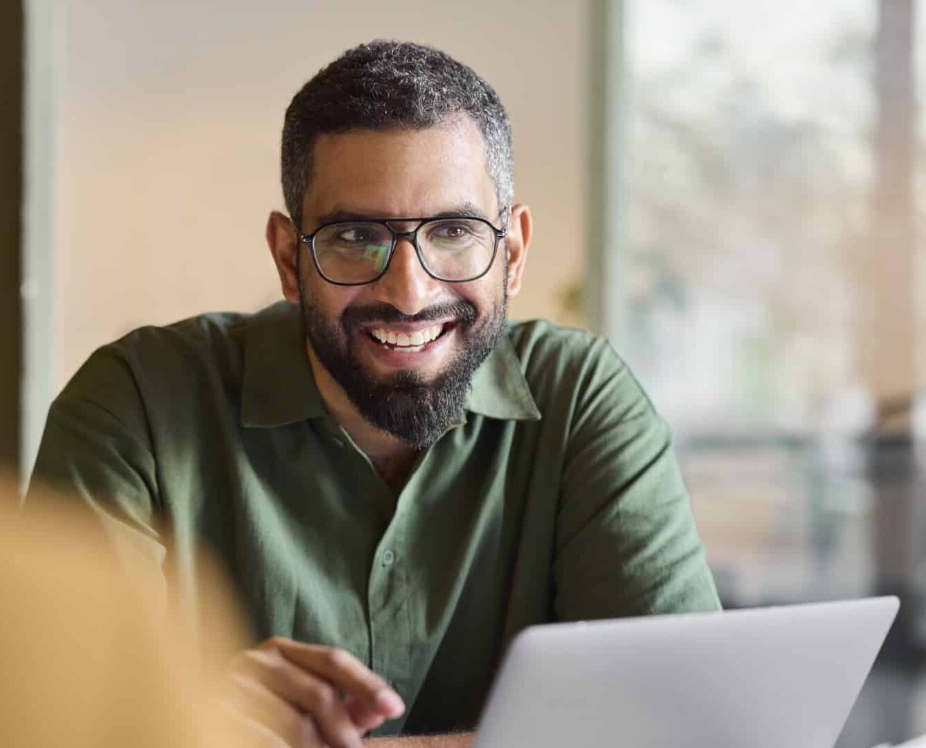 lachende man achter laptop